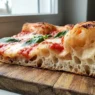 Trancio di pizza in teglia alla romana con vistosa alveolatura e bolle d'aria
