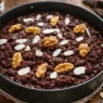 Una torta in una teglia con cioccolato noci e mandorle