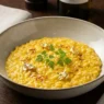 Piatto di risotto giallo alla milanese con pistilli di zafferano e foglia d'oro, stile gourmet