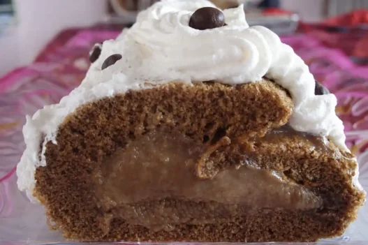 Rotolo di caffè con della panna montata e un chicco di caffè