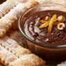 Vassoio di chiacchiere di Carnevale dorate e friabili coperte di zucchero a velo, preparate con il Bimby.