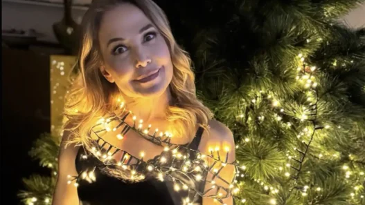 Barbara D'Urso sorridente mentre controlla lo smartphone, in riferimento al suo post su X