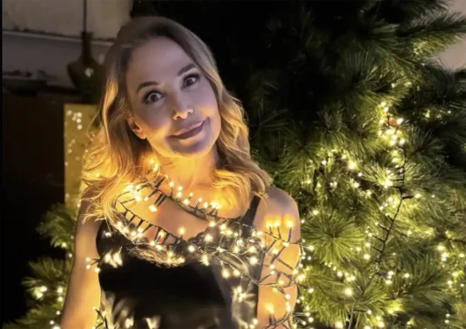 Barbara D'Urso sorridente mentre controlla lo smartphone, in riferimento al suo post su X