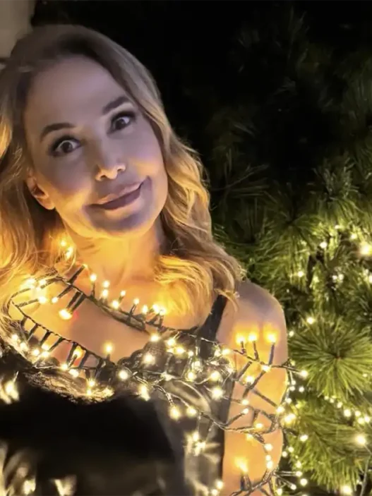 Barbara D'Urso sorridente mentre controlla lo smartphone, in riferimento al suo post su X