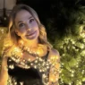 Barbara D'Urso sorridente mentre controlla lo smartphone, in riferimento al suo post su X