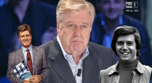 Primo piano di Claudio Lippi sorridente durante una trasmissione televisiva, a contrasto con la notizia del ricovero
