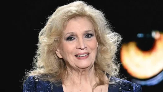 Iva Zanicchi sorridente con un mazzo di fiori, icona della musica italiana
