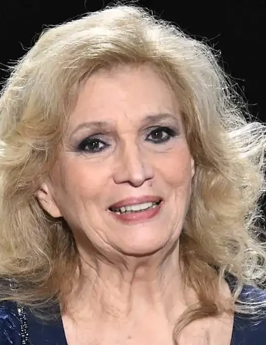 Iva Zanicchi sorridente con un mazzo di fiori, icona della musica italiana