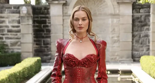 Margot Robbie indossa un completo rosso effetto pitone con corsetto e minigonna di Dilara Findikoglu durante la Paris Fashion Week 2026