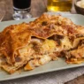 Un piatto di Lasagna di Carnevale con un bicchiere di vino accanto