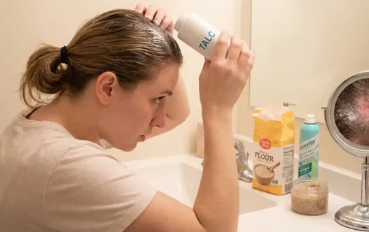 una ragazza che si mette del borotalco nei capelli