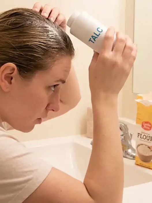 una ragazza che si mette del borotalco nei capelli