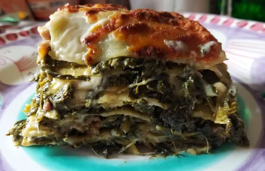Un piatto colorato sul quale è adagiata una fetta di lasagna salsiccia e friarielli