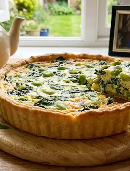 Un tavola apparecchiata con la quiche e la foto di re carlo