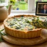 Un tavola apparecchiata con la quiche e la foto di re carlo