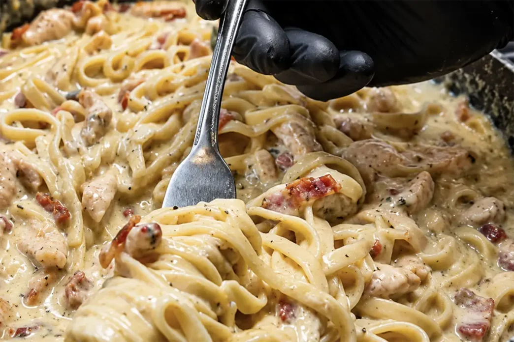 Un piatto di Carbonara chetogenica fumante con Shirataki noodles, guanciale croccante e crema di uova e pecorino.