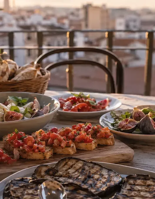 avola apparecchiata al tramonto con piatti freschi a base di fichi, pomodori e melanzane per una perfetta cena estiva in città.