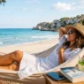 Una donna si rilassa su un'amaca in spiaggia a Ferragosto, ignorando lo smartphone spento per leggere il libro 'IL SILENZIO DEL MARE'.