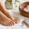 Una rilassante pedicure fai da te a casa con pediluvio e pietra pomice per curare i talloni screpolati e i piedi secchi.