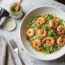 Piatto fresco di zoodles al pesto con gamberi saltati, ideale per la dieta chetogenica.